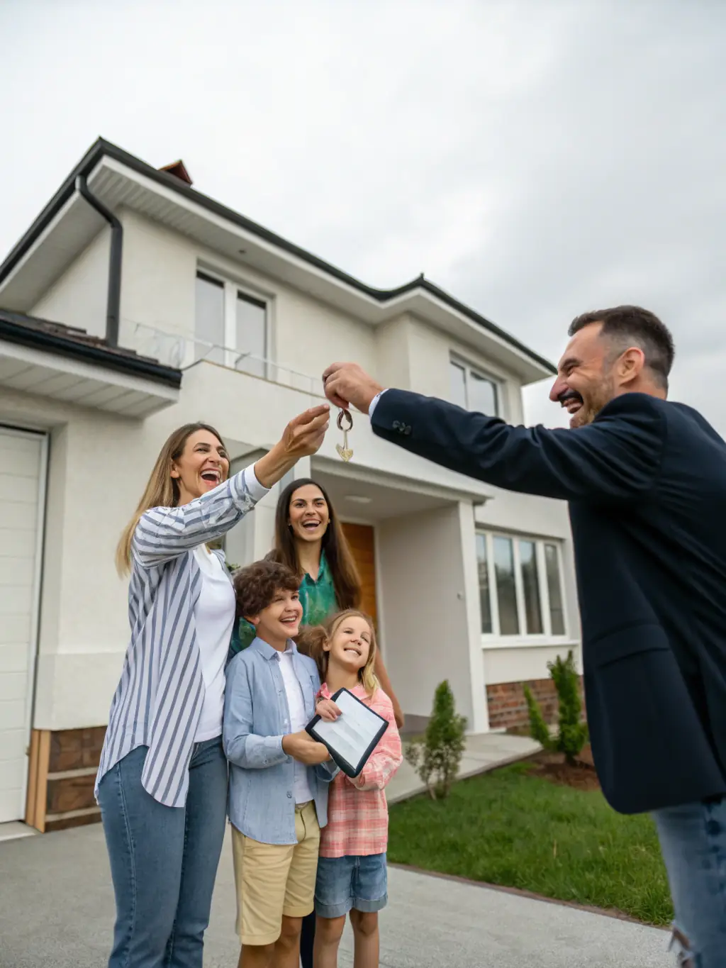 A photo of Jane Belongea handing over the keys to a happy couple in front of their new home, symbolizing the successful completion of the home-buying process.